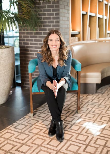 Isabelle Tierney CEO and Founder of The Stress Reset Isabelle Tierney, CEO and Founder of The Stress Reset seated in a chair facing the camera smiling.